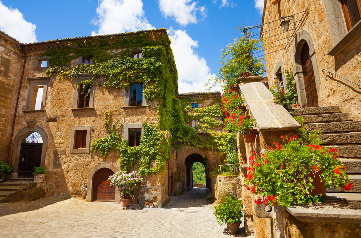 Square and Church of St. Donato. Civita di Bagnoregio through the flowers, Lazio, Italy